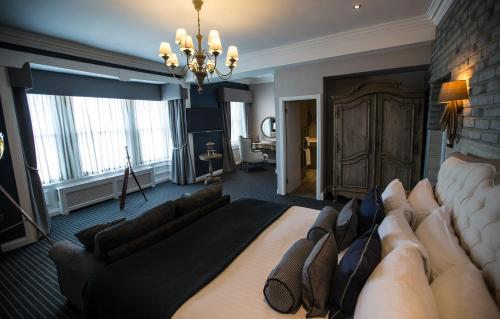 a large living room with a couch and a room with a chandelier at Roker Hotel BW Premier Collection in Sunderland