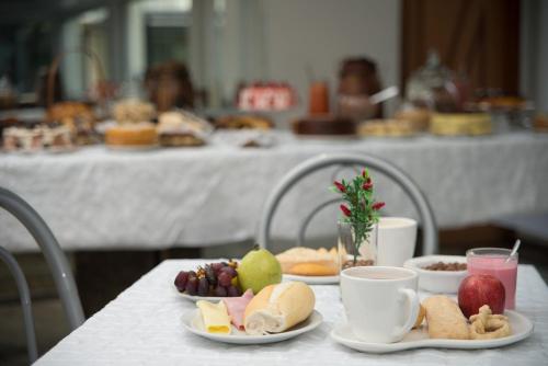 a white table with plates of food on it at Hotel Caiçara in Cachoeiro de Itapemirim