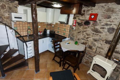 a small kitchen with a table and a sink at Talasnal Montanhas de Amor in Lousã