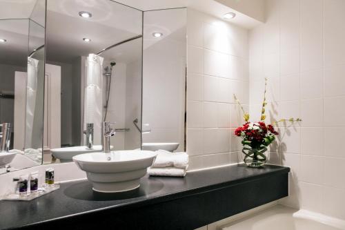 a bathroom with a sink and a mirror at Mercure Haydock Hotel in Haydock