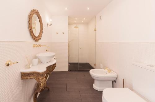 a bathroom with a sink and a toilet and a mirror at The Salt House in Olhão