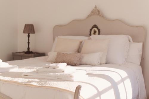 a white bed with white sheets and pillows at The Salt House in Olhão