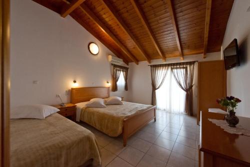 a bedroom with two beds and a window at Villa Coralli in Parga