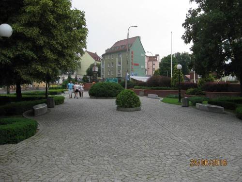 a walkway in a park with people walking down it at Hotel Kaliski in Słubice