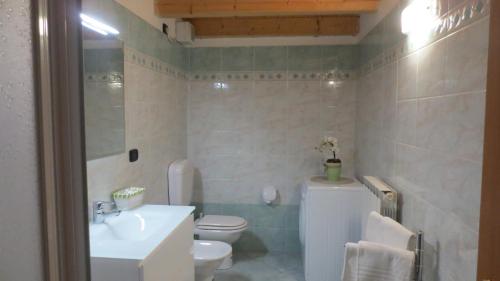 Łazienka z białą toaletą i umywalką w obiekcie Sweet Residence Tenno w mieście Tenno