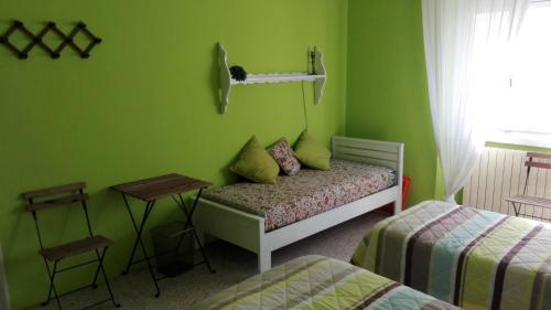a green room with a bed and a table at Bed and Breakfast Campel Inzago in Inzago