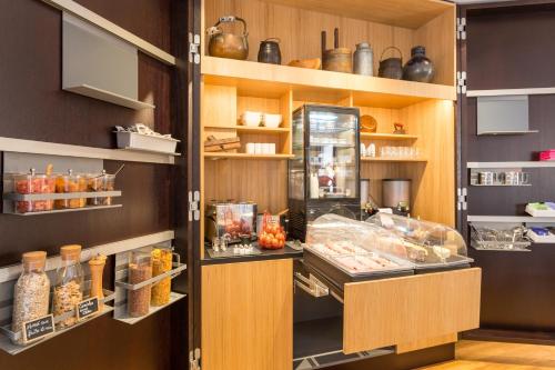 a display case in a kitchen with some food at Hôtel L'Auberge Alsacienne in Eguisheim