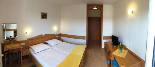 a bedroom with a bed and a desk and a television at Gostisce Golob in Zgornja Polskava