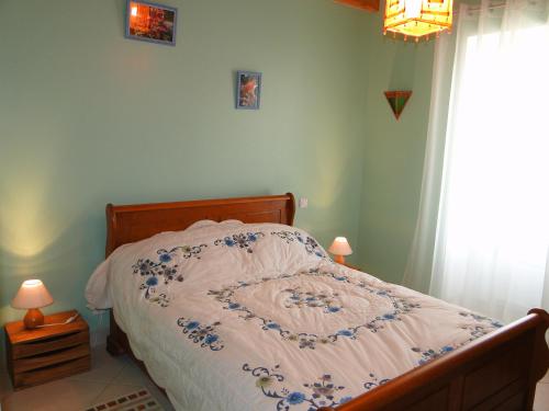 1 dormitorio con 1 cama con edredón azul y blanco en Le gite du gueurlet, en Boresse-et-Martron
