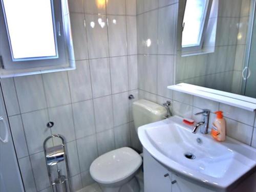 Un baño blanco con inodoro y lavabo. en Apartment Ajdukovic 2, en Vodice