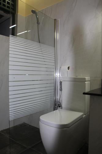 a white toilet in a bathroom with a shower at Colombo Airport Homestay in Gampaha