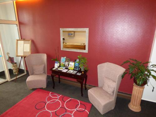 a waiting room with two chairs and a table at Logis Au Grand Hotel et son restaurant in Mayenne