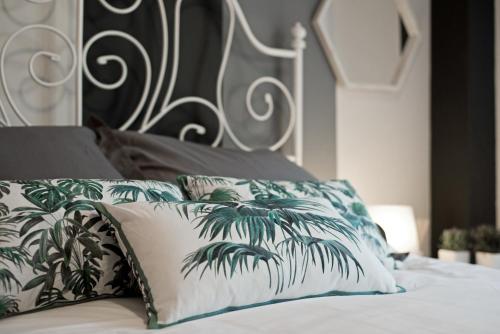 Una cama con almohadas verdes y blancas. en OFFLINE -- pacos, en Fuengirola
