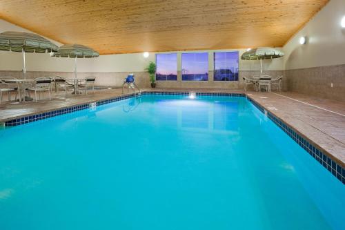 uma grande piscina com água azul num quarto de hotel em AmericInn by Wyndham Osage em Osage