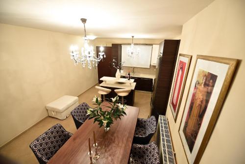 a living room with a dining table and a kitchen at Ninos Luxury Apartment in Corfu Town