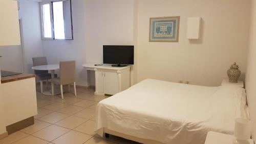 ナポリにあるSan Giacomo 32 Residenceのベッドルーム(ベッド1台、テーブル、テレビ付)