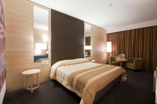 a hotel room with a bed and a chair at Centrum Palace Hotel & Resorts in Campobasso