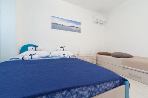 a white bedroom with a blue bed and a mattress at Appartamenti DueC in Trapani