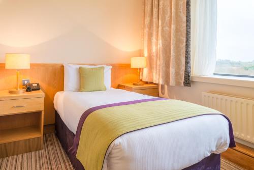 A bed or beds in a room at Knock House Hotel