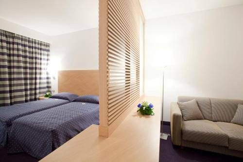 a bedroom with a blue bed and a couch at Centrum Palace Hotel & Resorts in Campobasso