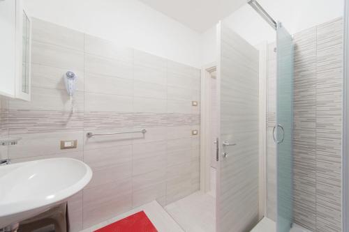 a white bathroom with a shower and a sink at Appartamenti DueC in Trapani