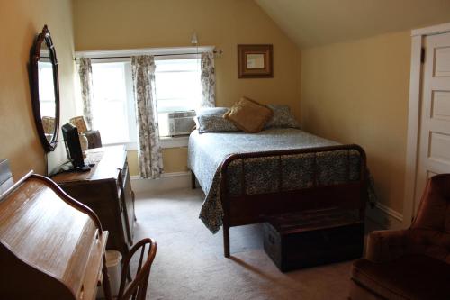 una piccola camera da letto con un letto e una finestra di Victorian Charm Inn a Towanda