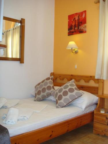 a bed with two pillows on it in a room at Boussetil Rooms CapAnMat in Tinos Town