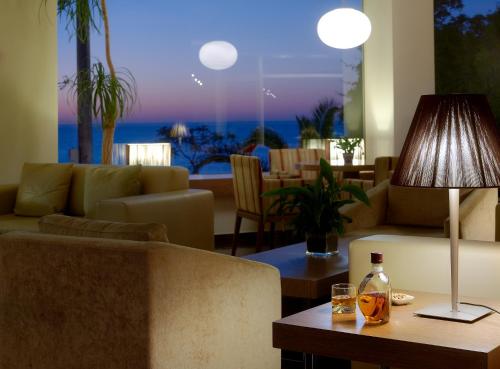 a living room with a couch and a table with a lamp at Irida Hotel in Chania