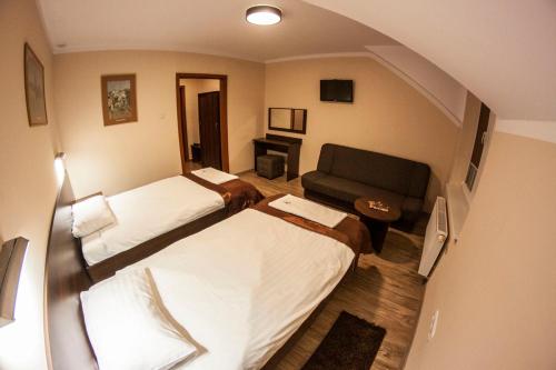 a hotel room with two beds and a couch at Pensjonat i Klub Jeździecki Michelin in Włocławek