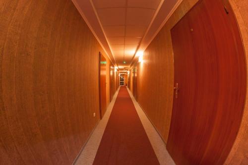a corridor of a hallway with wooden walls and a long aisle at Pensjonat i Klub Jeździecki Michelin in Włocławek