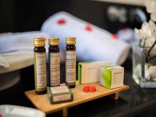 three bottles of essential oils and a box on a table at Sirayane Boutique Hotel & Spa Marrakech in Marrakesh