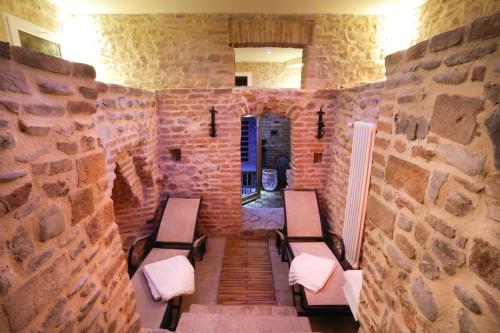 a room with benches in a stone wall at Castello di Marano sul Panaro - Room & Breakfast in Marano sul Panaro