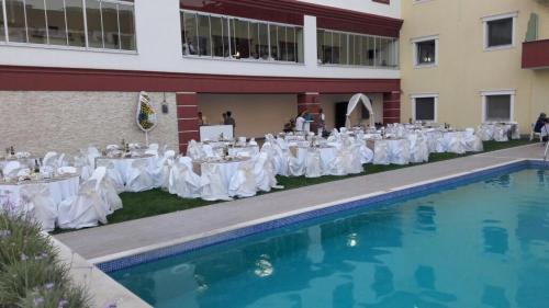a group of tables and chairs next to a swimming pool at Hotel Labella Bergama in Bergama