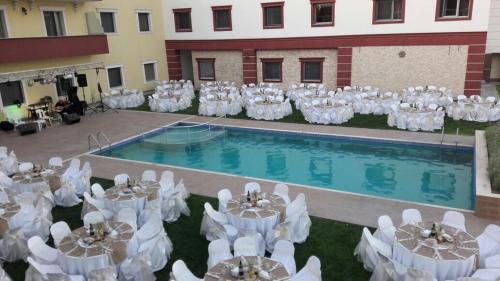 a group of tables and chairs in front of a pool at Hotel Labella Bergama in Bergama