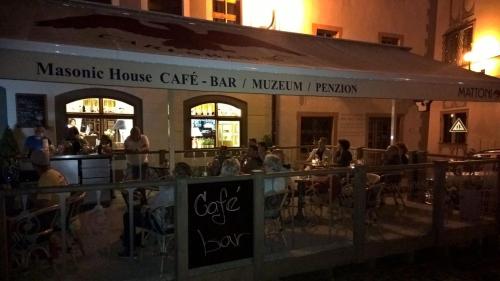 a group of people sitting at a cafe at night at Pension Masonic House in Loket