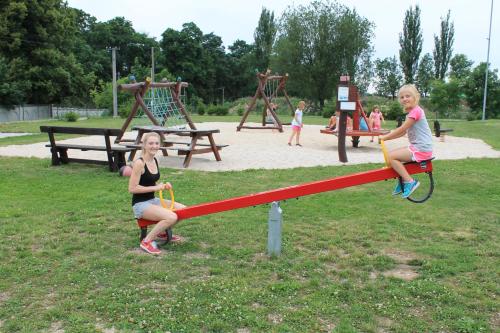 two girls playing on a zip line in a park at Pension Jezdecké centrum Kočík in Stružná