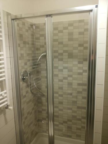 La salle de bains est pourvue d'une douche avec une porte en verre. dans l'établissement Appartamentino Acquamarina, à Montesilvano