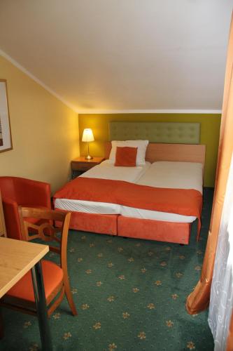 a hotel room with a bed and a table at Hotel Kreuzwirt in Engerwitzdorf