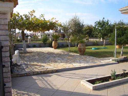 a garden with trees and a stone walkway at Aspri Villa in Ammoudia
