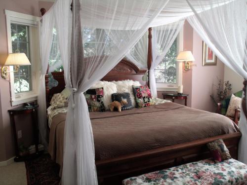 a bedroom with a canopy bed with a teddy bear on it at Inn to the Woods in Friday Harbor