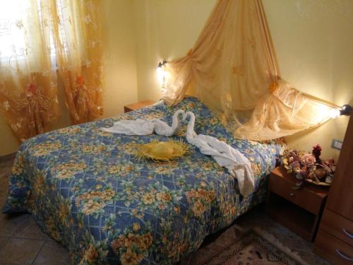 Un dormitorio con una cama con un cisne. en Villettemire en Capo Vaticano