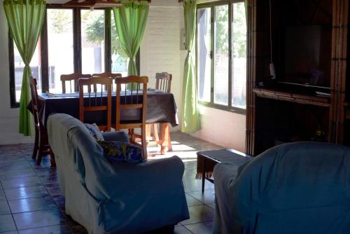 sala de estar con sofá, mesa y sillas en Samadi Hostel Uspallata en Uspallata