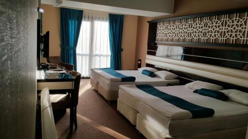 een hotelkamer met drie bedden en een tafel bij Hotel La Bella Soma in Soma