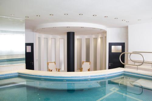 a pool in a hotel with two chairs in it at Let Sun Hotel Boutique in Buenos Aires