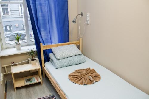 een klein bed in een kamer met een raam bij Hostel Oras in Vilnius