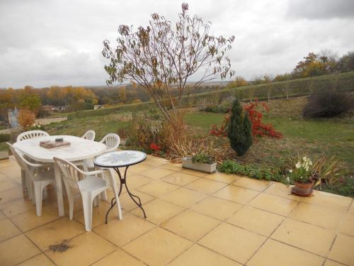 a patio with a table and chairs and a field at maison la croix chambre chez l ' habitant in Marsac