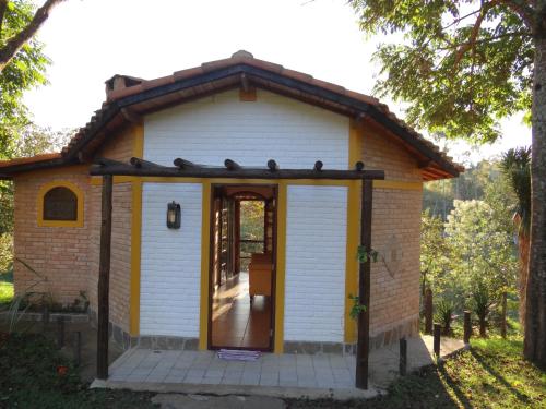 a tiny house with a porch and a door at Hotel Fazenda dos Anjos in Cambuquira