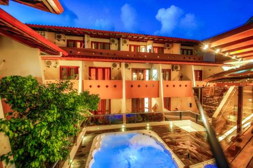 a hotel with a swimming pool in front of a building at Rede Andrade Terra Brasil in Porto Seguro