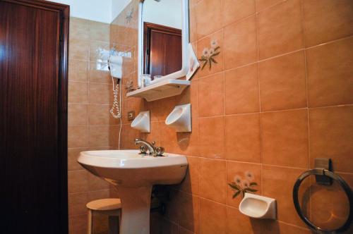 uma casa de banho com um lavatório e um espelho em Hotel Meri 1956 Locanda e Cucina em Framura