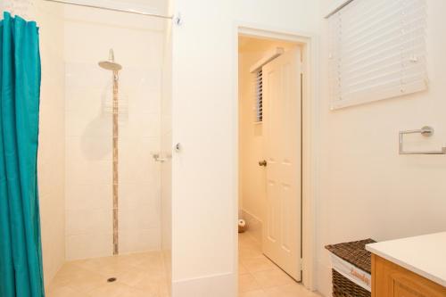 a shower with a glass door in a bathroom at Reflections Broome in Broome